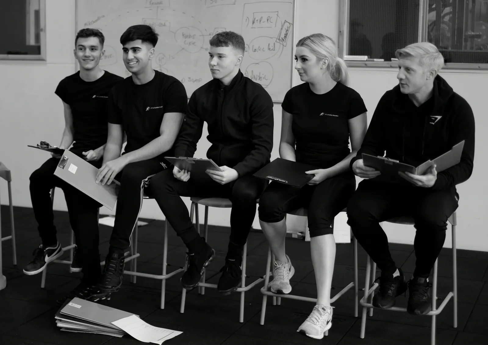 Learners with clipboards in a gym classroom