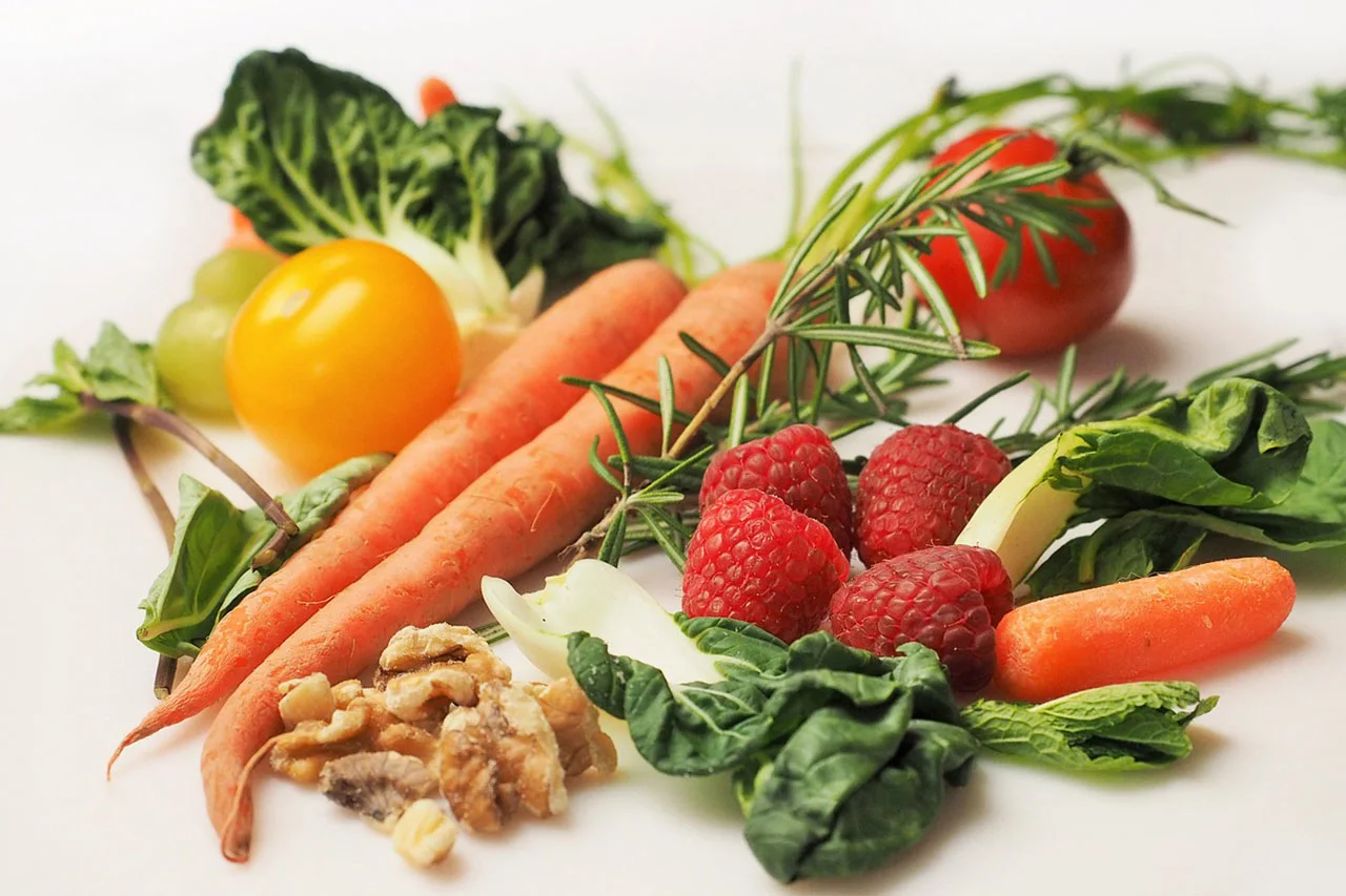 Fresh vegetables, fruit and nuts on a board