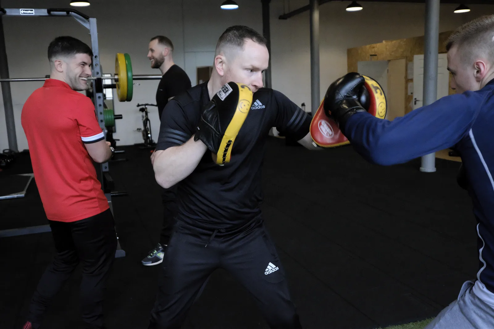 Pad work: a learner striking focus pads held by a tutor