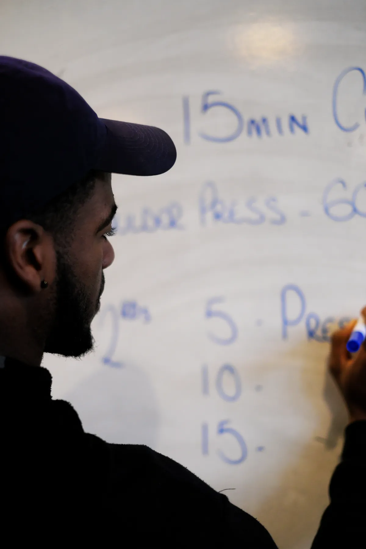 A tutor writing a session plan on a whiteboard